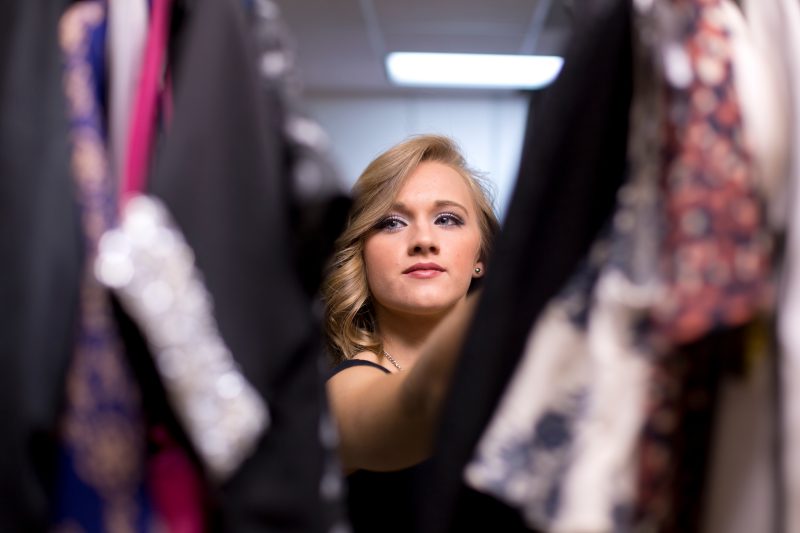 student adjusting clothes on manakin in apparel window display