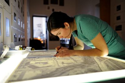 Student drawing on top of light box.