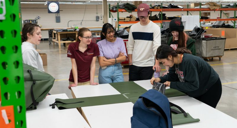 Six students working on a backpack design together.
